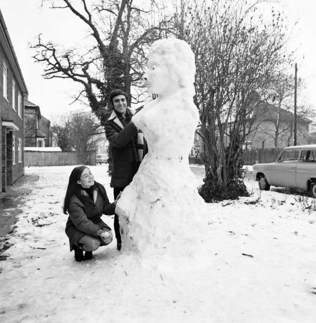 A couple building their snow-woman, 1969.