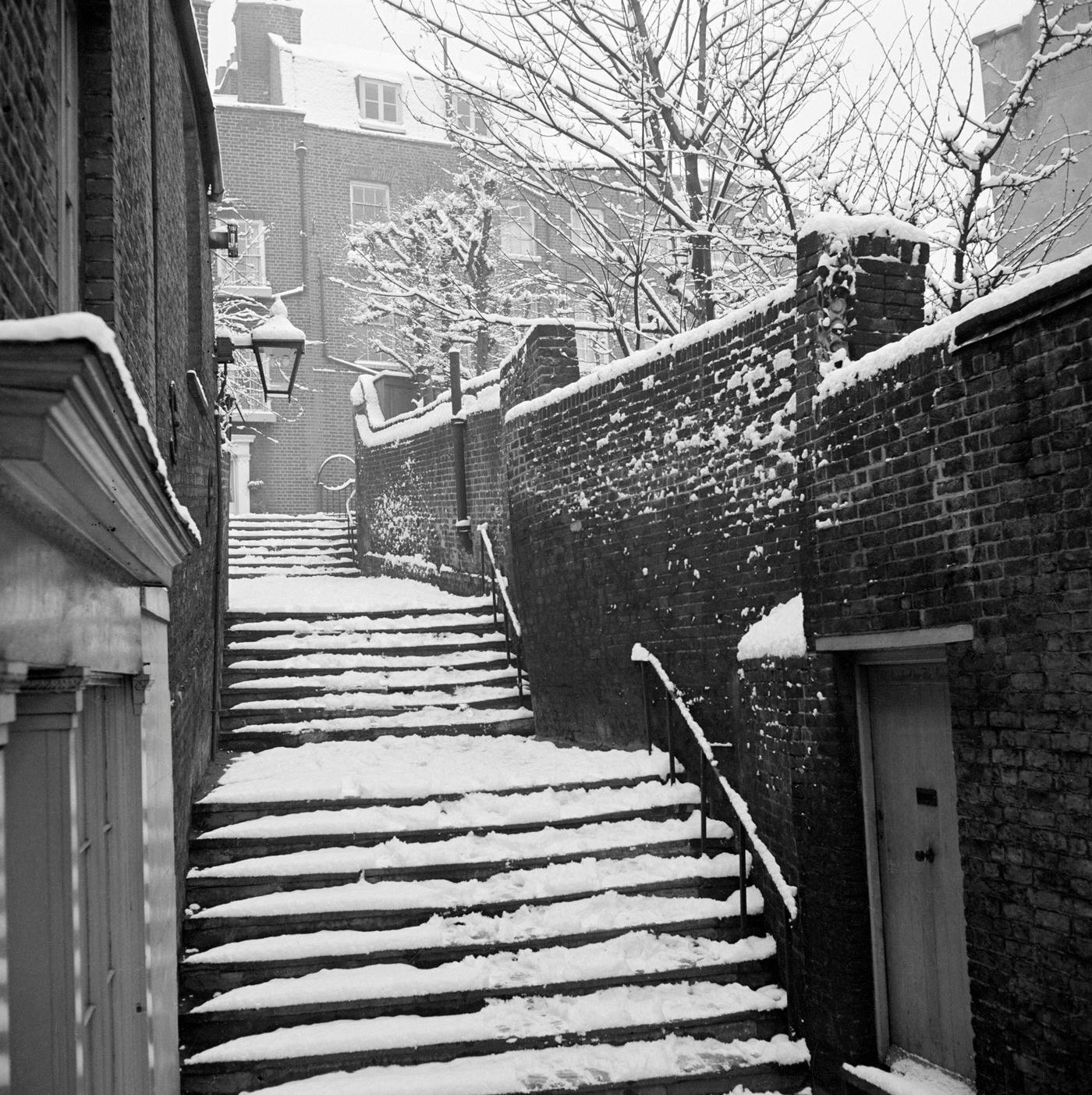 Three flights of steps in the snow, part of the narrow passage running between Heath Street and Hampstead Grove.