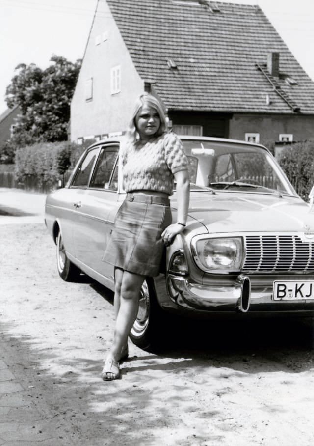 A young blonde lady posing with a Ford Taunus 20M in a residential street on the outskirts of town. The car is registered in West Berlin, 1968