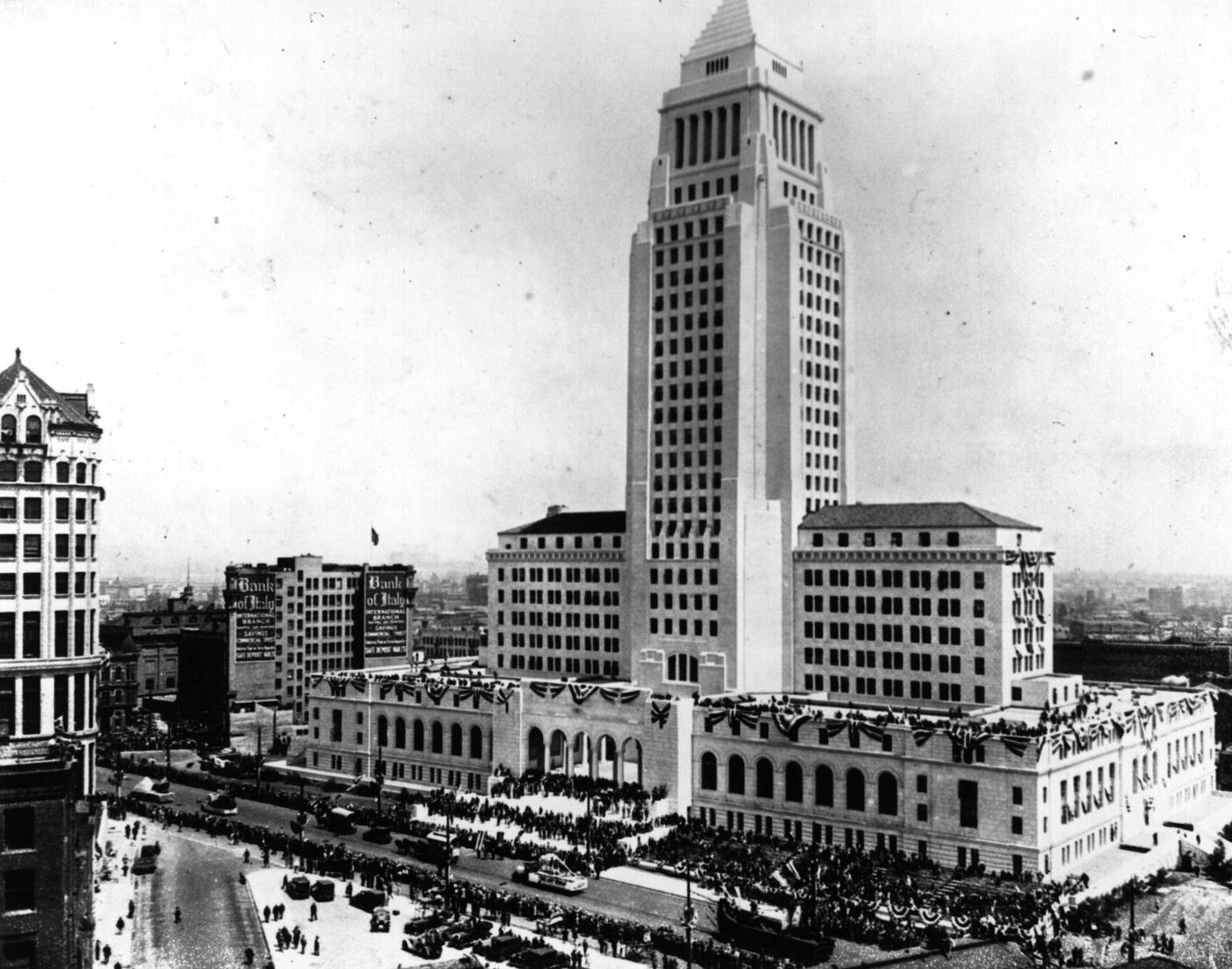 A procession passes Los Angeles' new $10,000,000 City Hall at the opening ceremony for the building which is surmounted by the Lindbergh Beacon 500 feet above street level - December 4, 1930.
