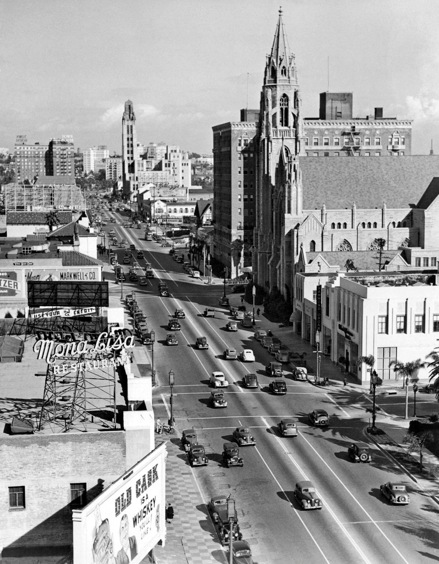 Wilshire Boulevard at Catalina, with the Mona Lisa Restaurant at the left, the Immanuel Presbyterian Church across the street, and Bullock's Wilshire Department Store tower can be seen further west on Wilshire, Los Angeles, 1938.