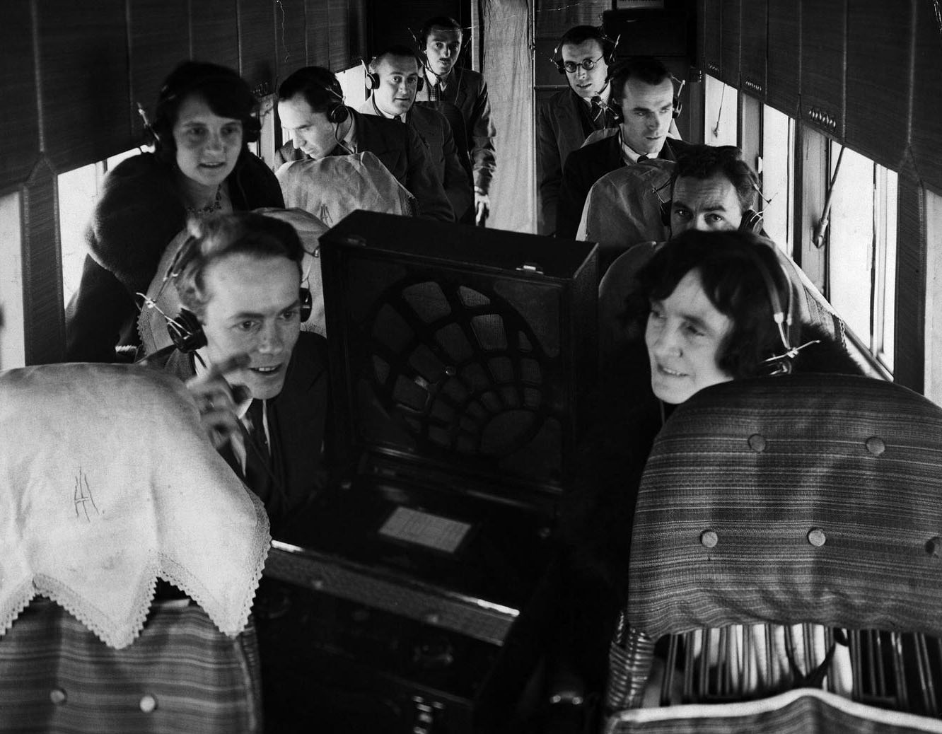 Wireless communications make it possible for passengers aboard an Imperial Airways plane to hear the derby results via headphones.