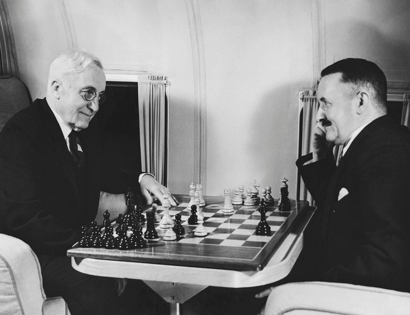 Two male passengers play chess on a Pan American Clipper seaplane flying between San Francisco and Hong Kong, Hawaii, and Manila.