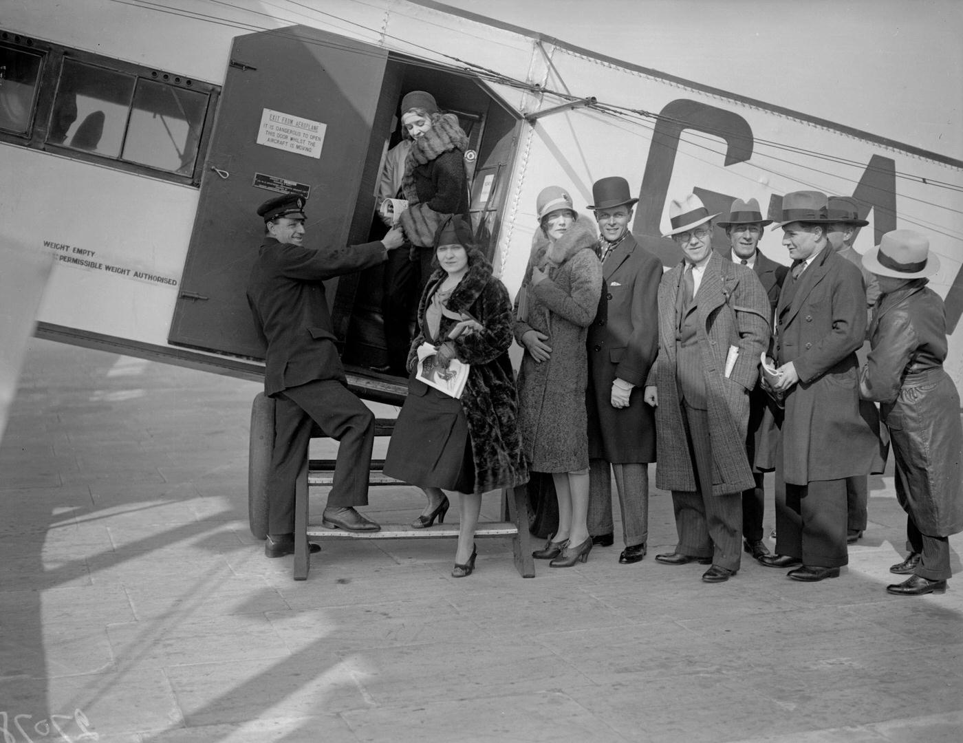 Passengers board an aircraft at Croydon Airport in London, bound for the Grand National horse race in Liverpool.