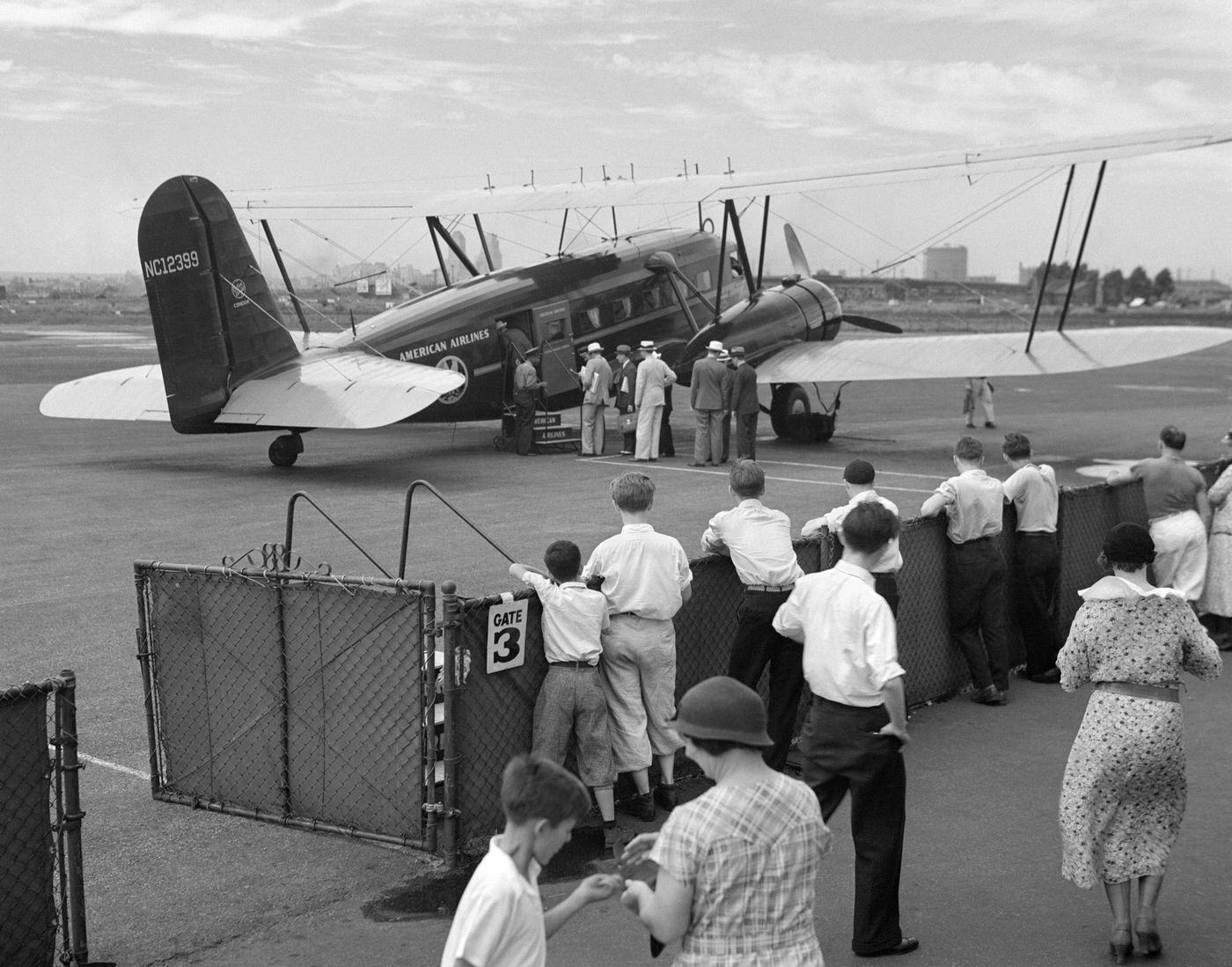 Passengers board an American Airlines Condor biplane airplane for commercial flight from Newark, New Jersey, 1930s