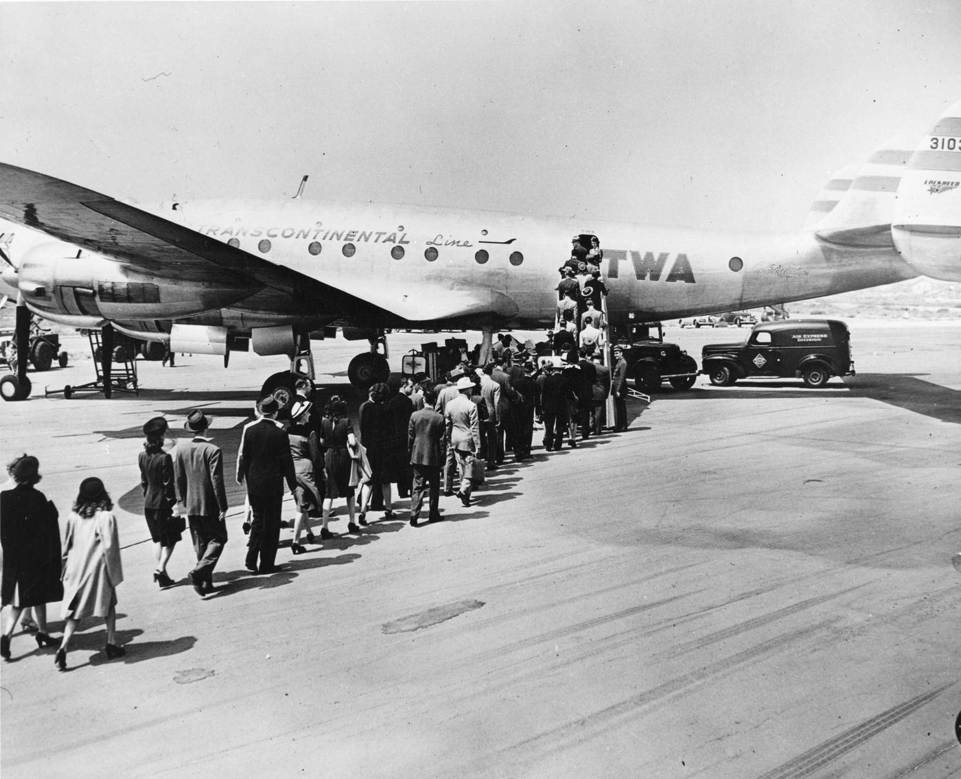 Passengers are boarding a Lockheed 'Constellation' on the tarmac at an unidentified airport in 1946. The plane could accommodate 57 passengers and a crew of seven and fly coast-to-coast in 6 hours, 58 minutes.