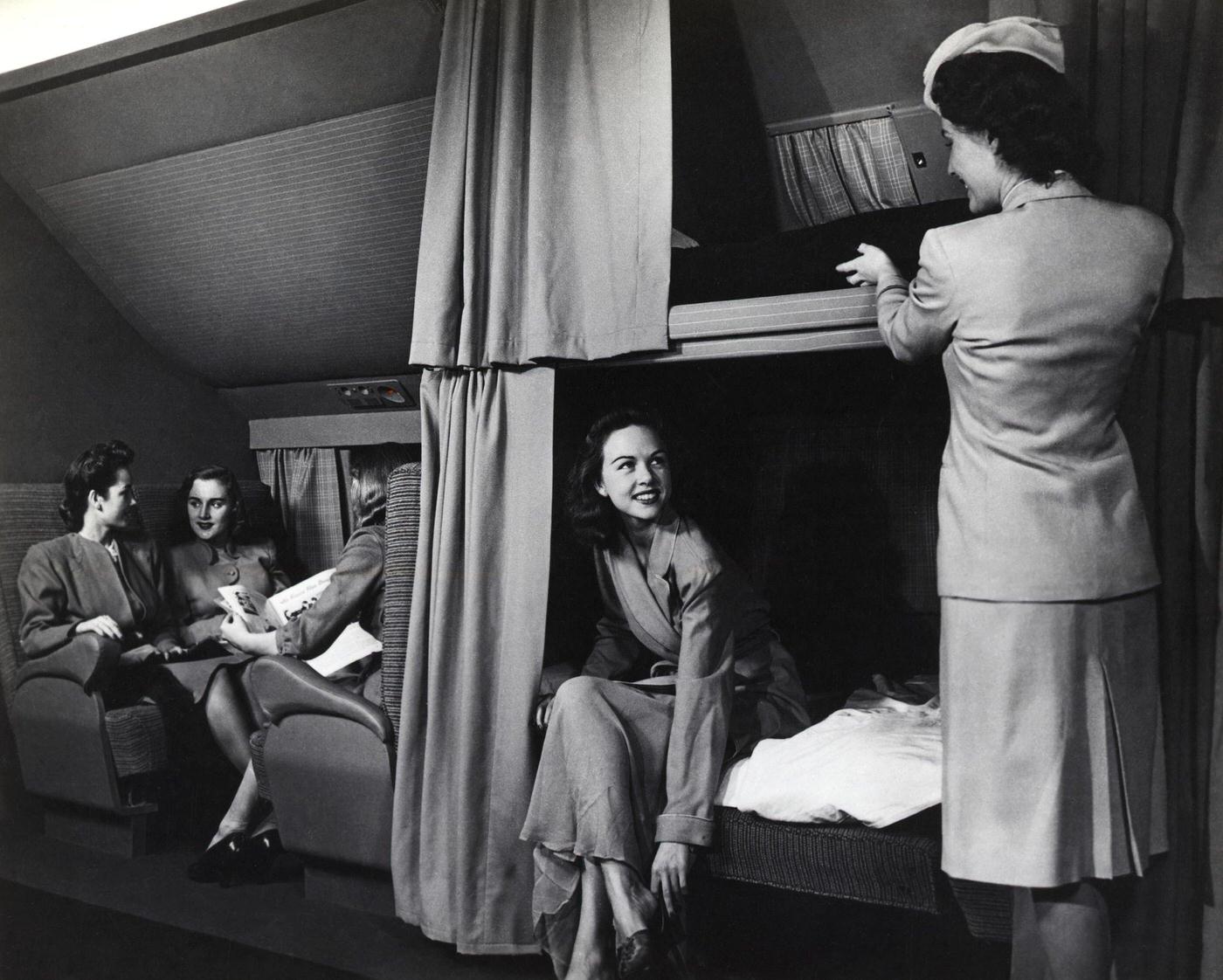 The interior of a McDonnell Douglas DC-6 is shown with flight attendants working with passengers to make the cabin comfortable.