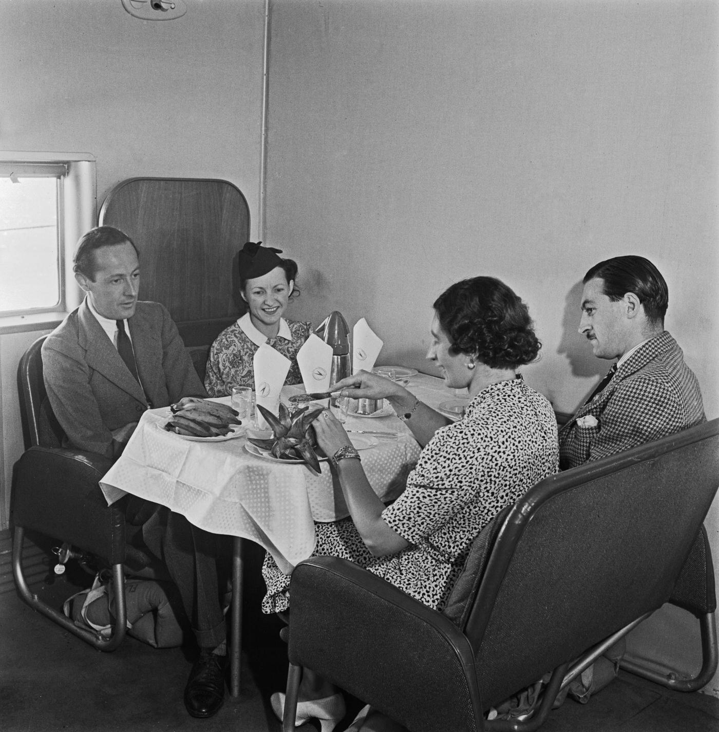 Four passengers are enjoying a meal at a table aboard the British Overseas Airways Corporation (BOAC) Boeing 314A Clipper flying boat Berwick on an international flight from England during World War II on 31st August 1942.