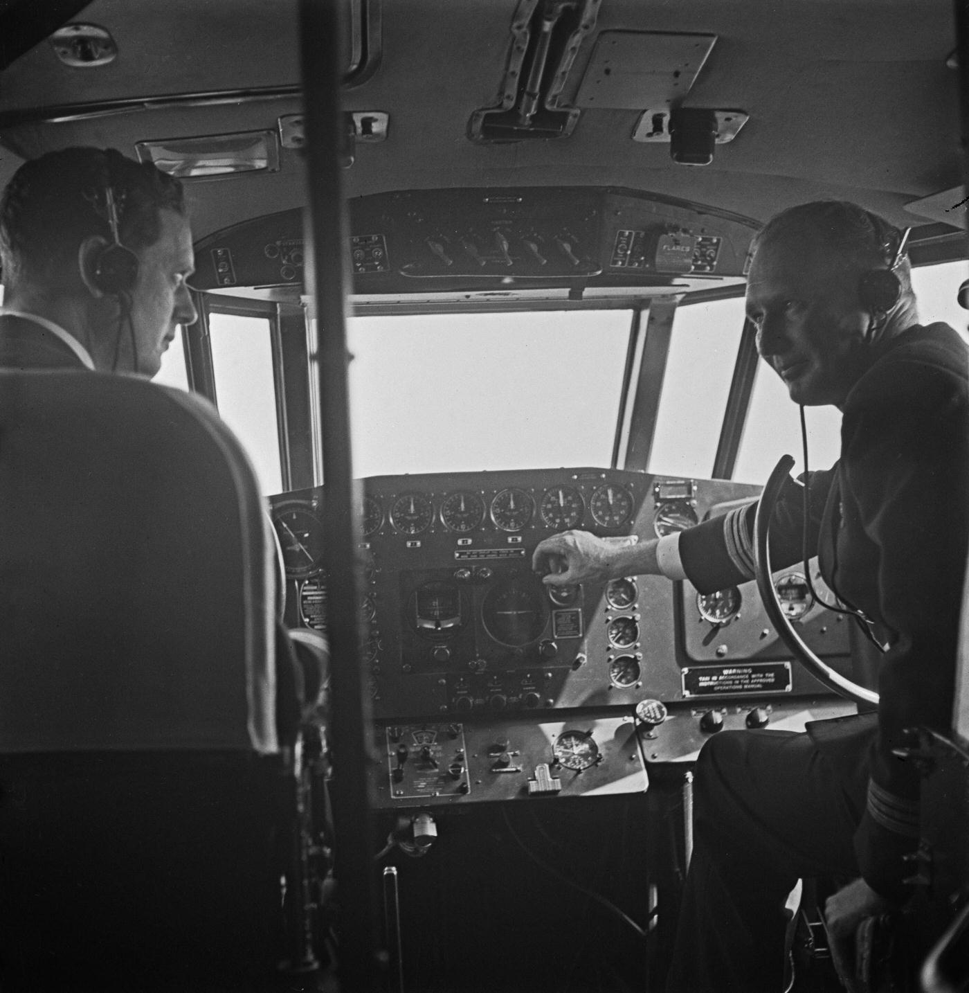 Captain D Peacock (on the left) and Captain Bill Craig are seated in the cockpit of the British Overseas Airways Corporation (BOAC) Boeing 314A Clipper flying boat Berwick (registration G-AGCA) prior to flying the aircraft on an international flight from England in 1942.