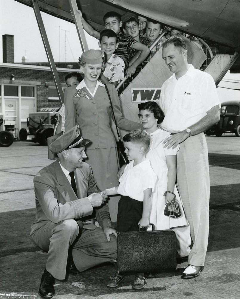 A TWA pilot and stewardess greet the passengers coming off the plane, 1950