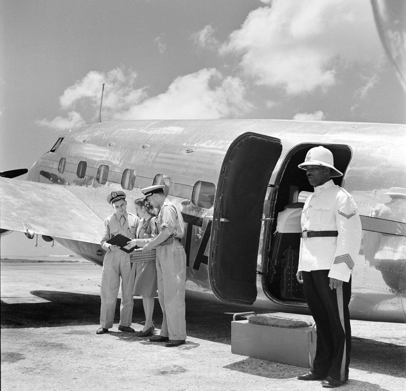 The flight crew reviews the passenger list of a British West Indian Airlines plane at Piarco International Airport in Piarco, Trinidad, British West Indies, in 1952.