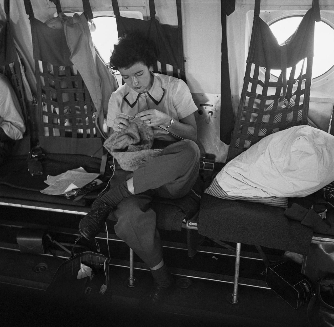 A female soldier knits while traveling to a military base on a plane, as seen in a Cosmopolitan magazine photo.