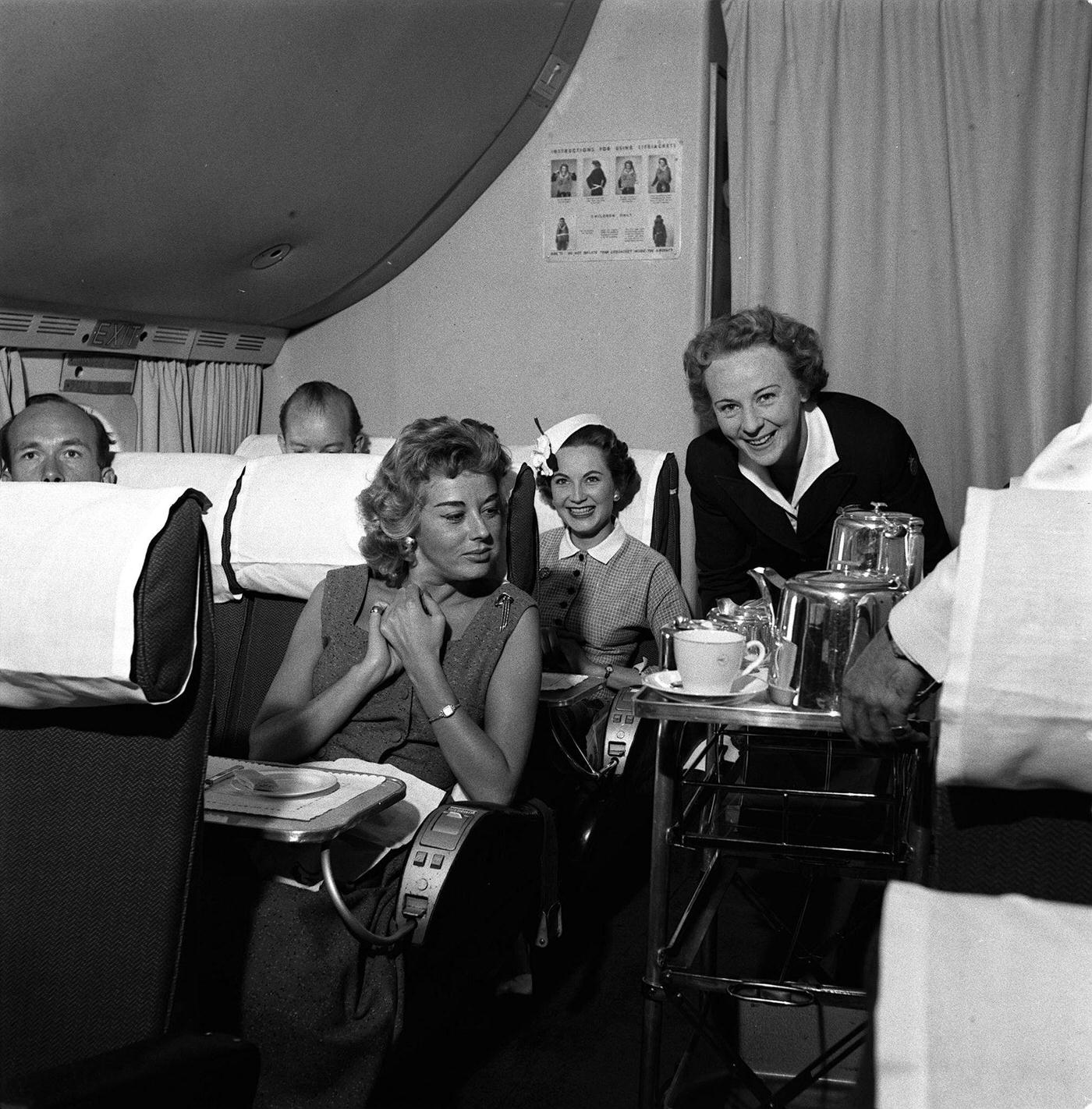 Air hostess Irene Mallory is seen serving food to passengers on her trolley in 1955.
