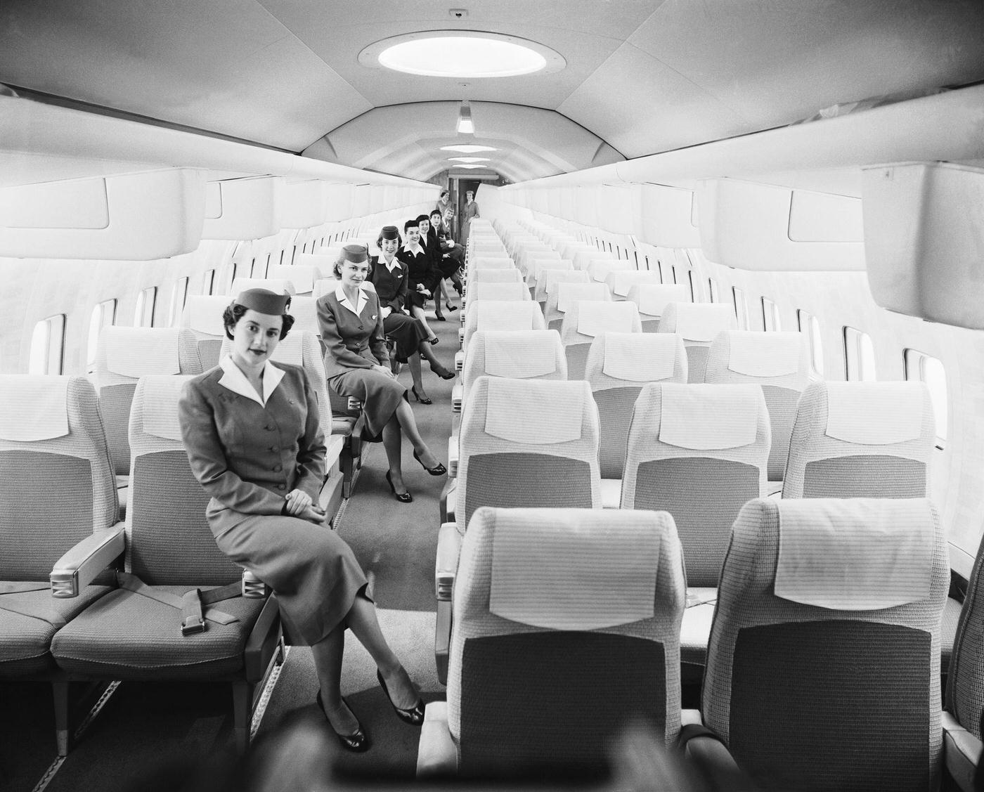 A group of airline stewardesses pose inside the luxurious mockup of the Boeing Jet Stratoliner, which will enter service with airlines worldwide in 1959.