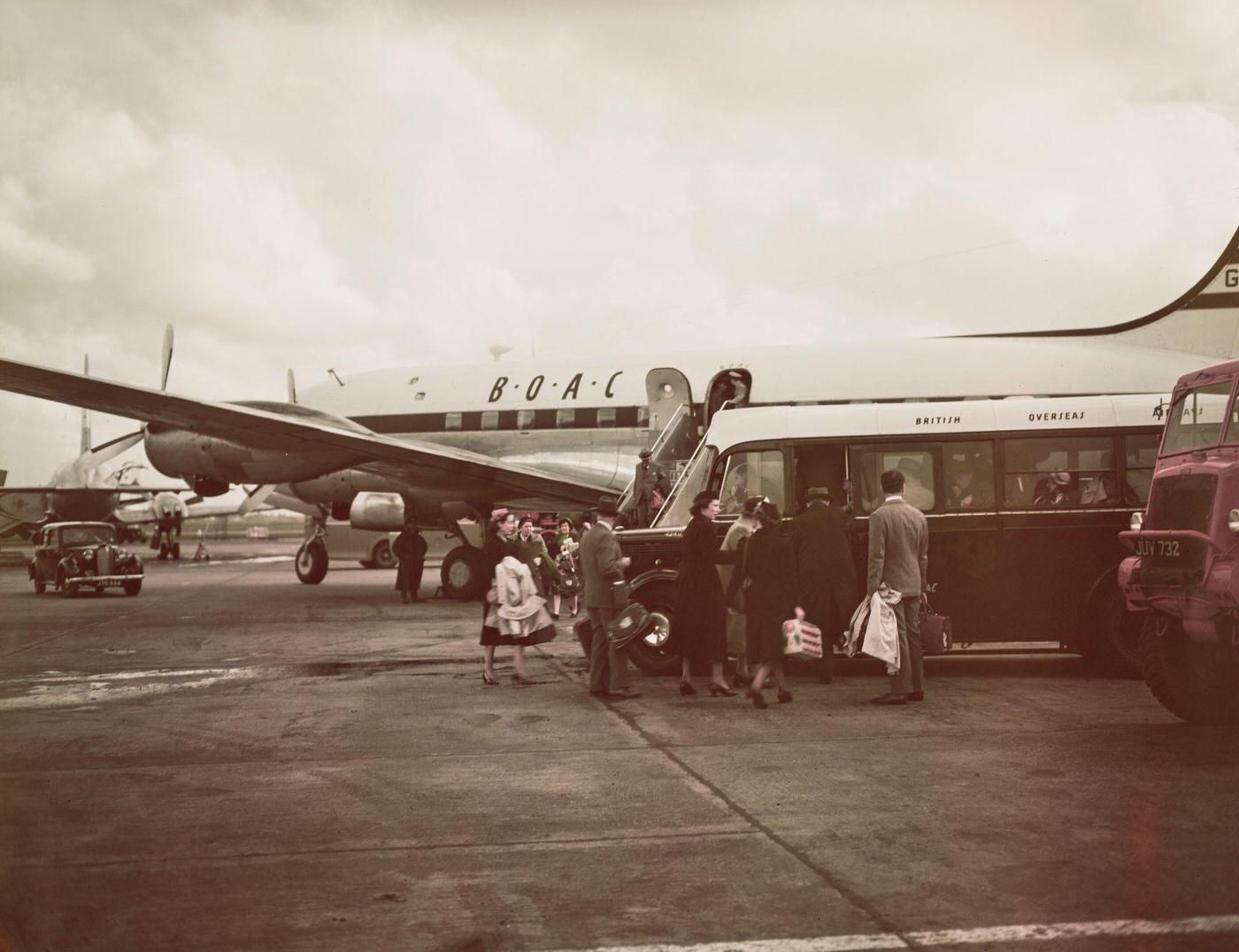Passengers disembark from a British Overseas Airways Corporation (BOAC) Canadair C4 Argonaut aircraft onto a shuttle bus at London Airport in June 1951.
