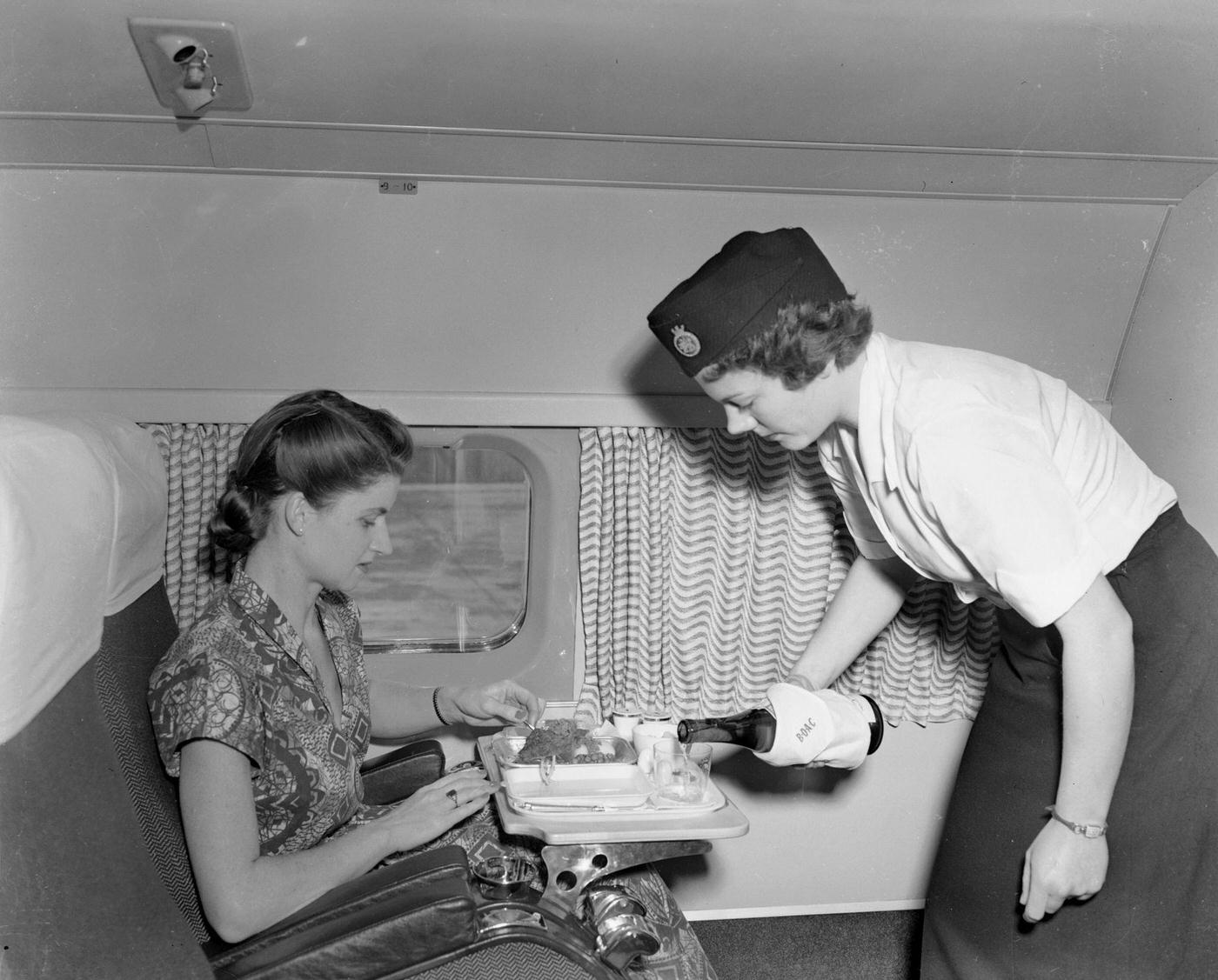 A passenger on board the world's first jet airliner service receives luncheon from E Courtney, a member of the cabin crew. The Comet flight is headed for South Africa.