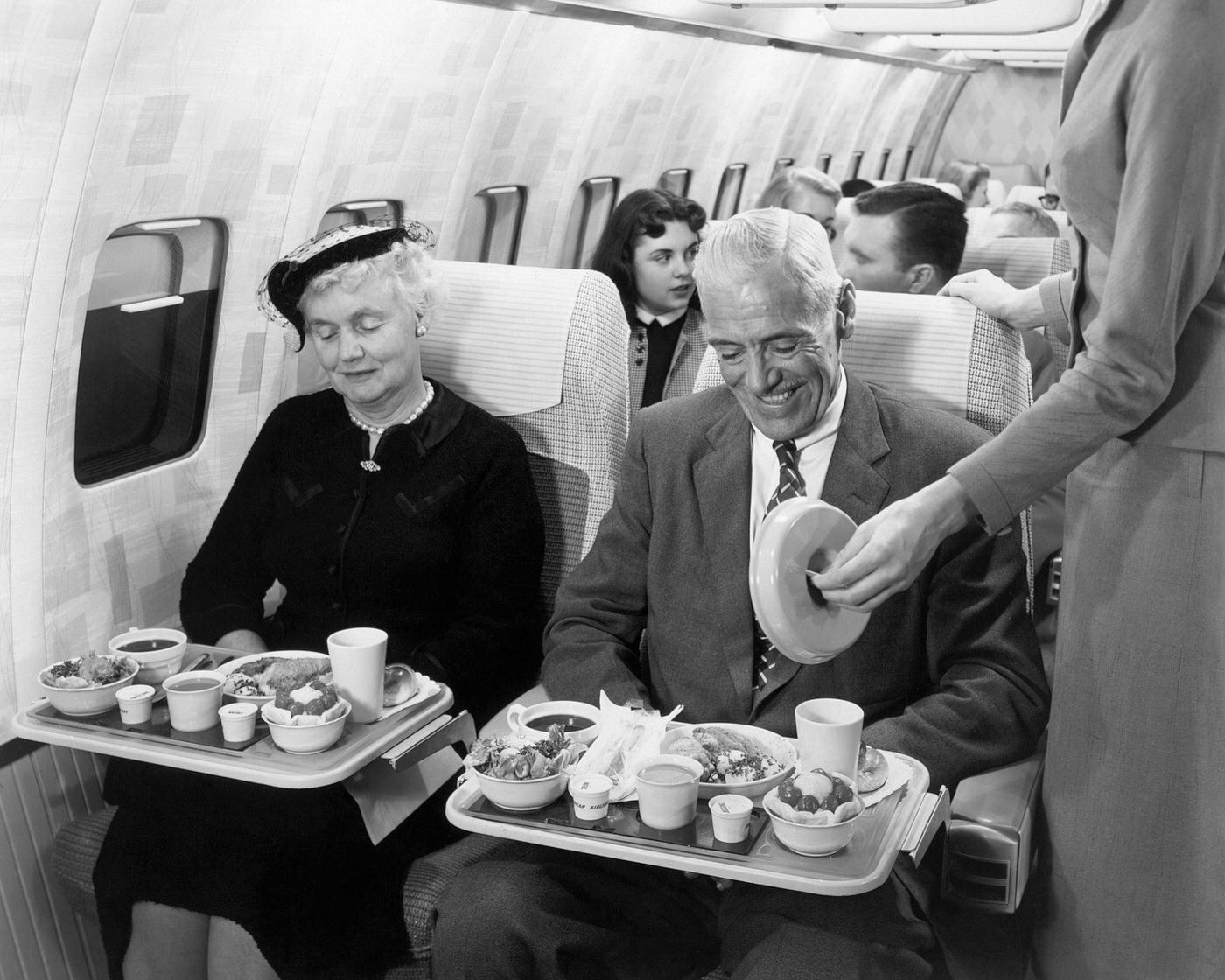 Passengers enjoying a meal inside a mock-up of the Boeing 707 Stratoliner. The development of the Stratoliner began in the 1950s during the race to capture the commercial airline market.