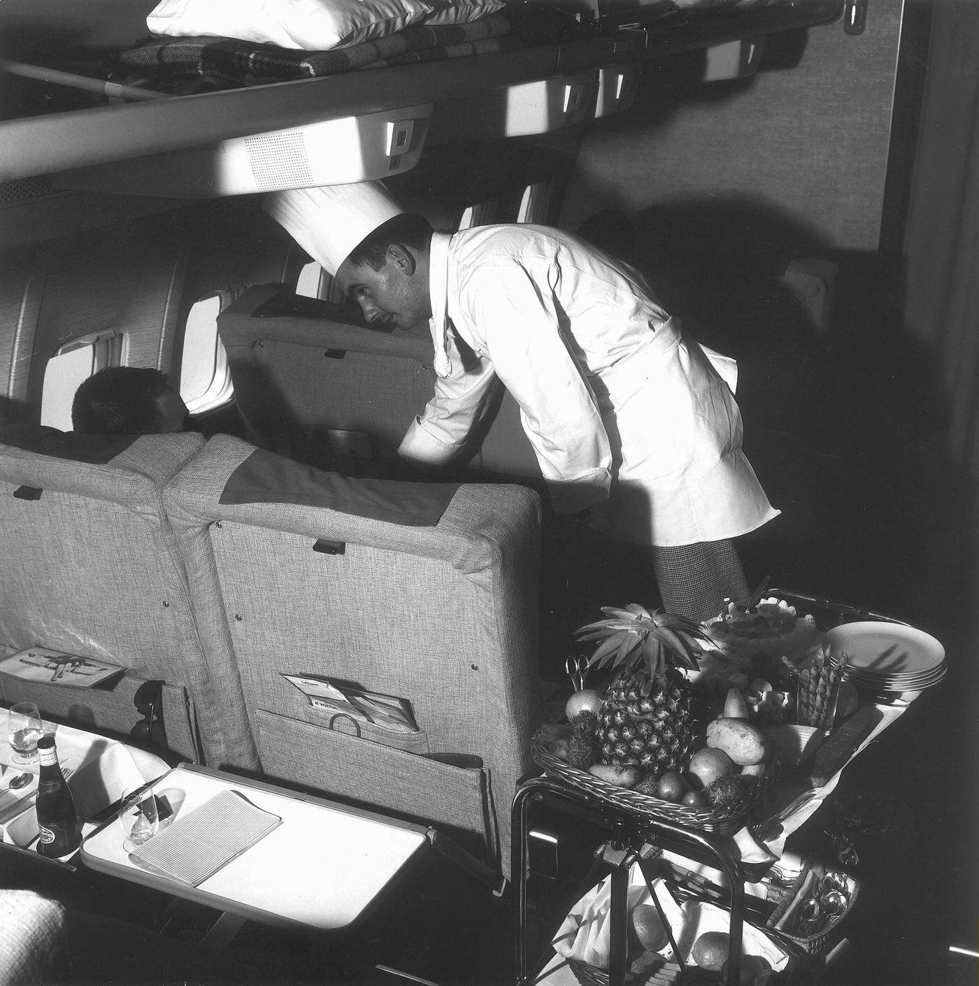 First-class airline service with a chef serving food, Germany 1960s.