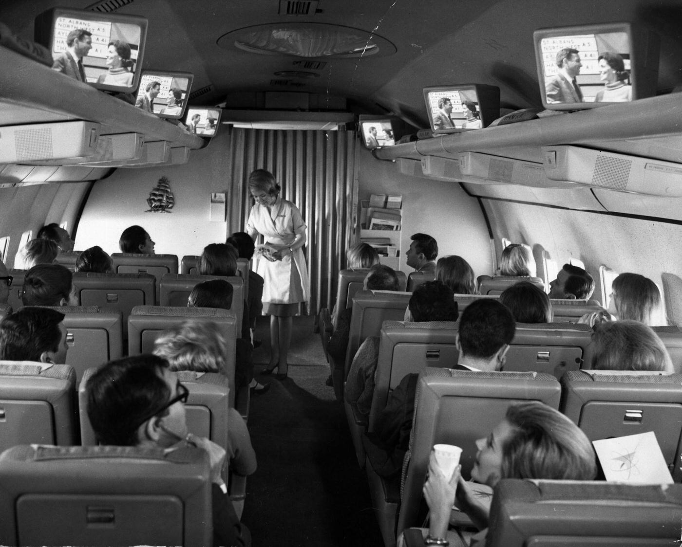 Test flight of a new Pan American Airlines plane fitted with television sets in the hand luggage racks for the entertainment of passengers, 1965.