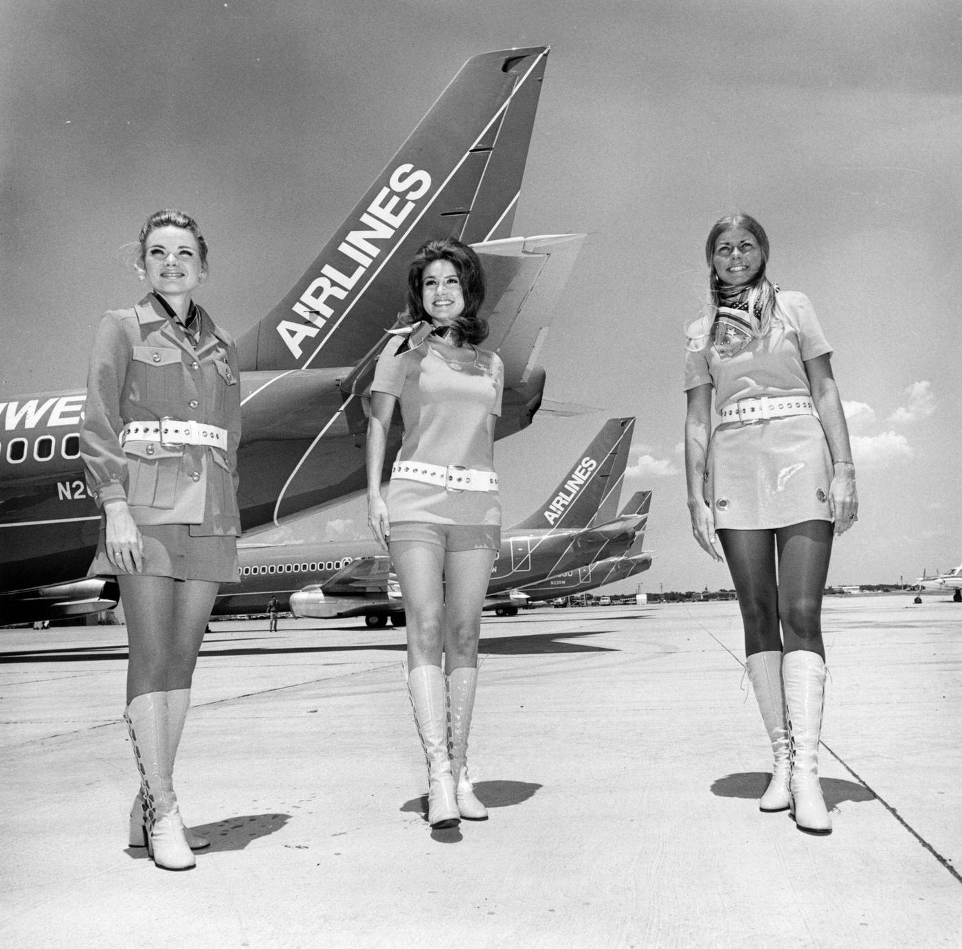 Southwest Airlines stewardesses in Texas standing in front of planes belonging to the airline. 1968.