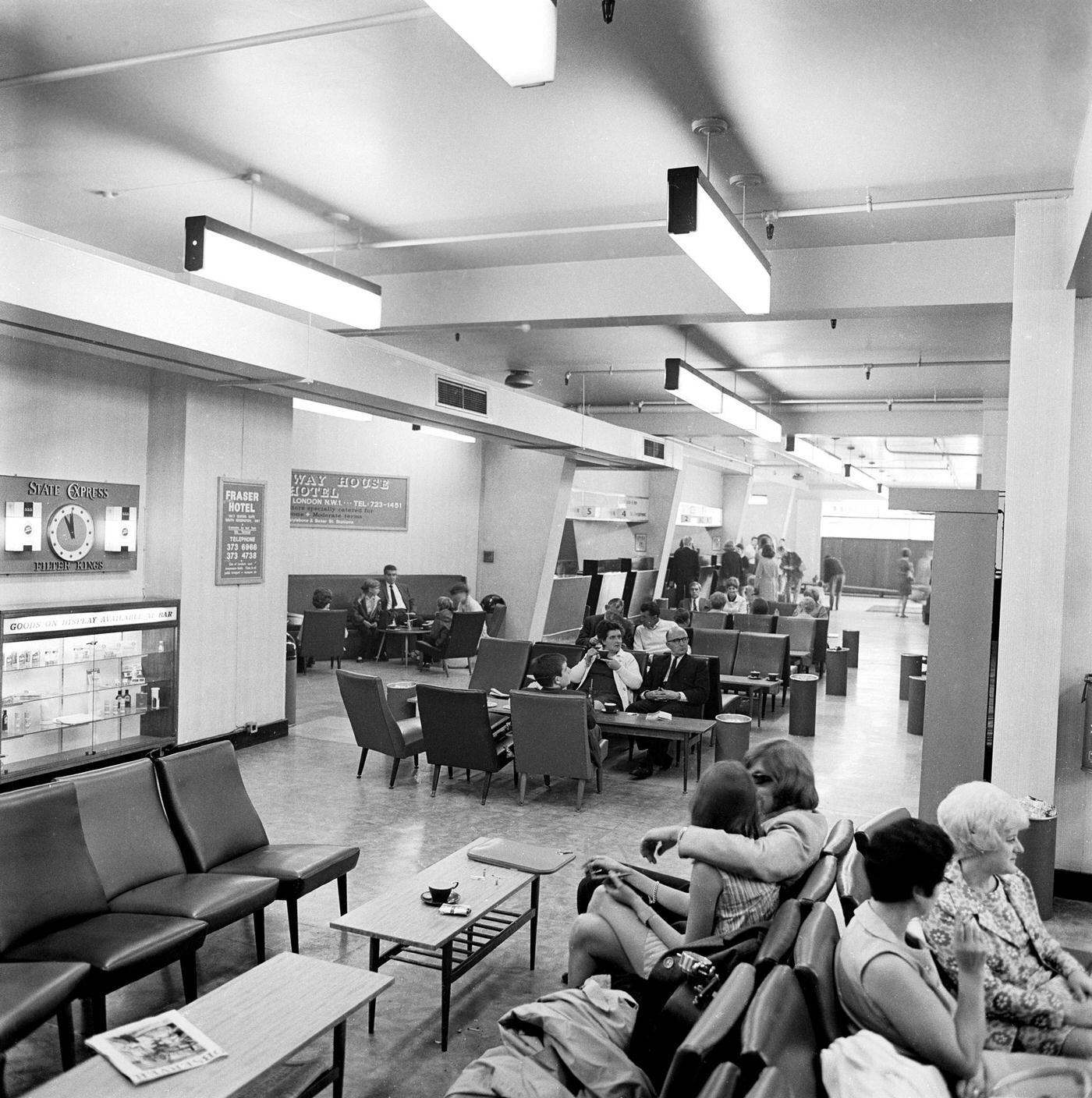 Passengers sitting in a waiting area of the British Eagle International Airlines terminal at Knightsbridge Air Terminal, London, 1960