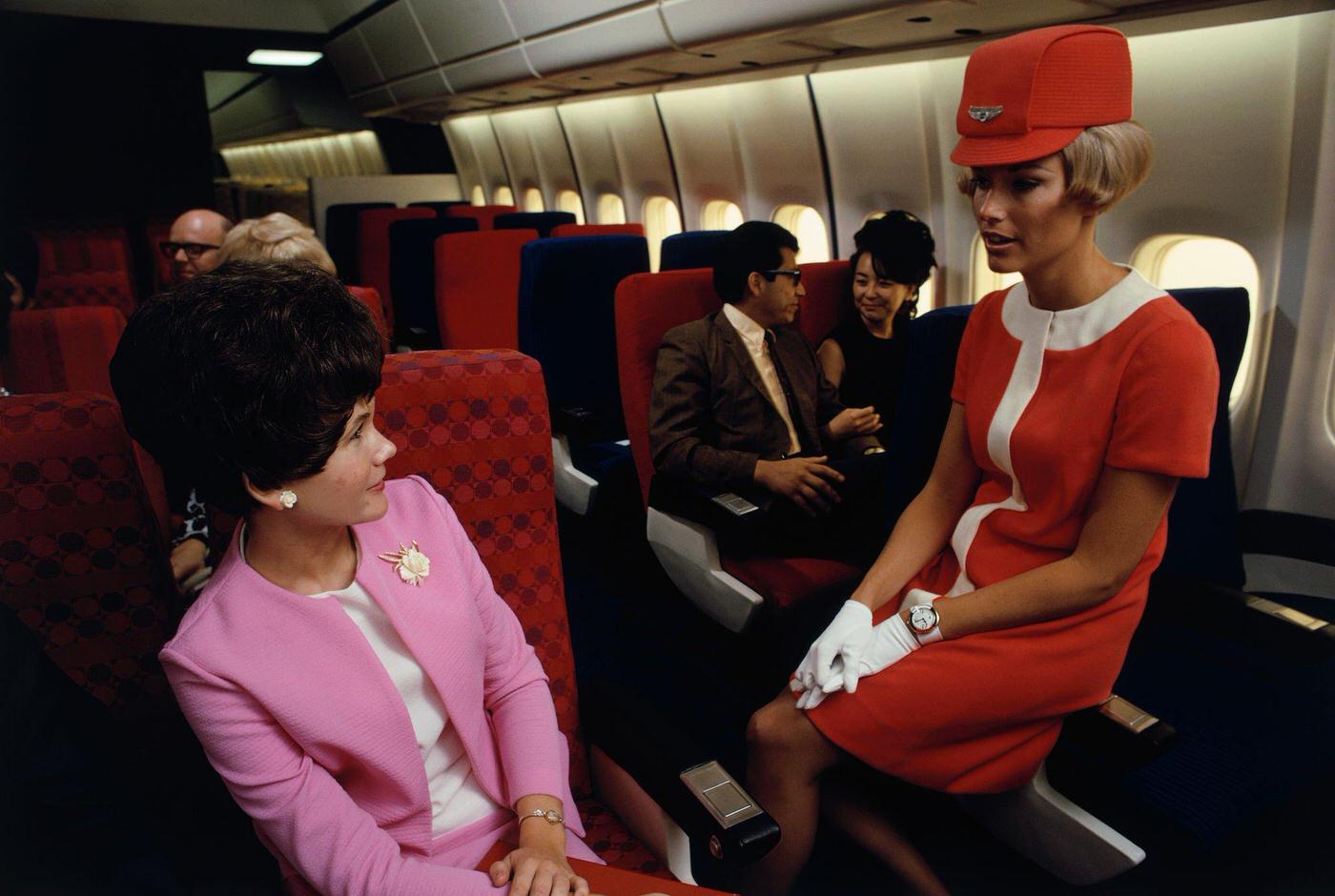 A United Airlines flight attendant talks with a passenger in a simulated passenger compartment of a Douglas DC-10.