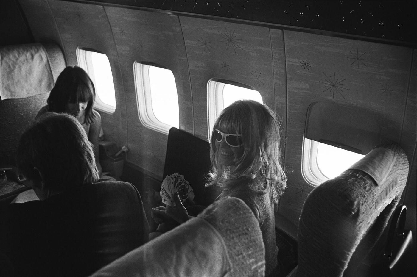 Brigitte Bardot playing cards on a flight from New York to Los Angeles in December 1965.