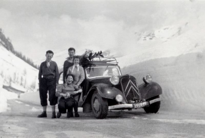 Four people with Citroën 11 CV on snowy mountain road, Rhône registration, 1952