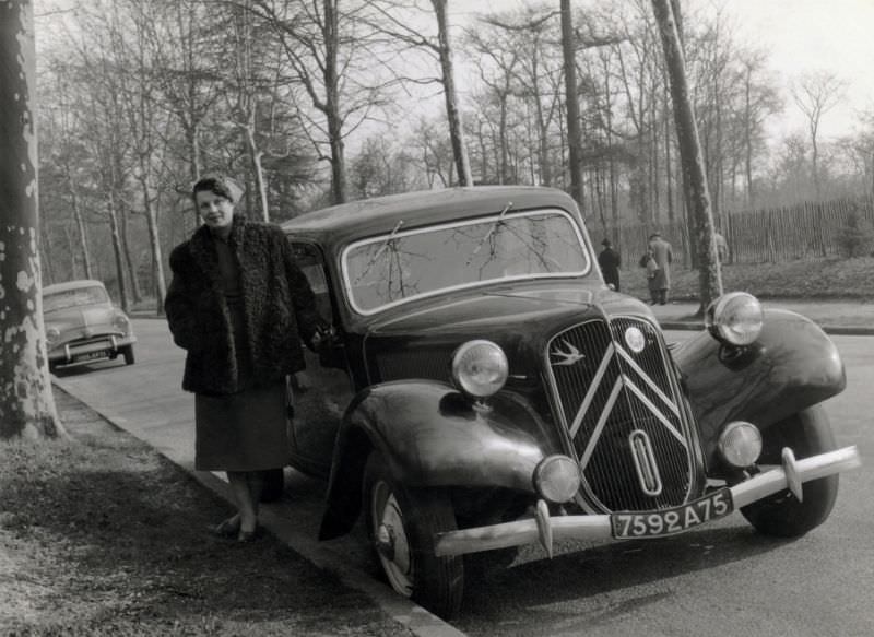 Lady in fur coat with Citroën 11 CV on tree-lined avenue, Paris registration, 1955