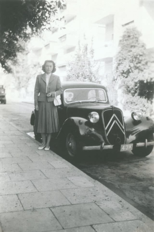 Lady with Citroën 11 CV in residential street with Israeli plates, 1955