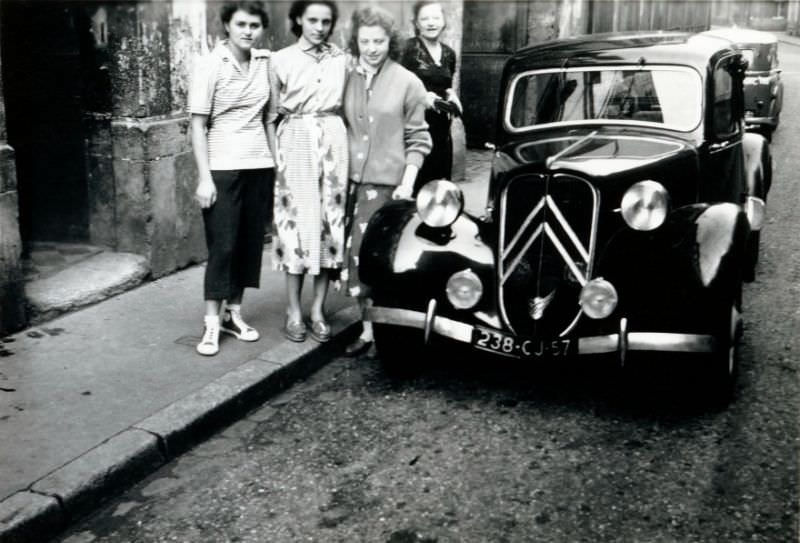 Four ladies with Citroën 11 CV in shabby residential street, Moselle registration, 1955