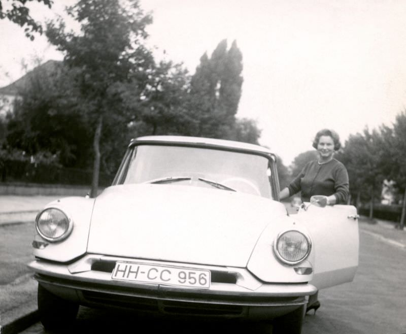 Stylish lady with Citroën DS in tree-lined city street in summertime, Hamburg registration, 1960