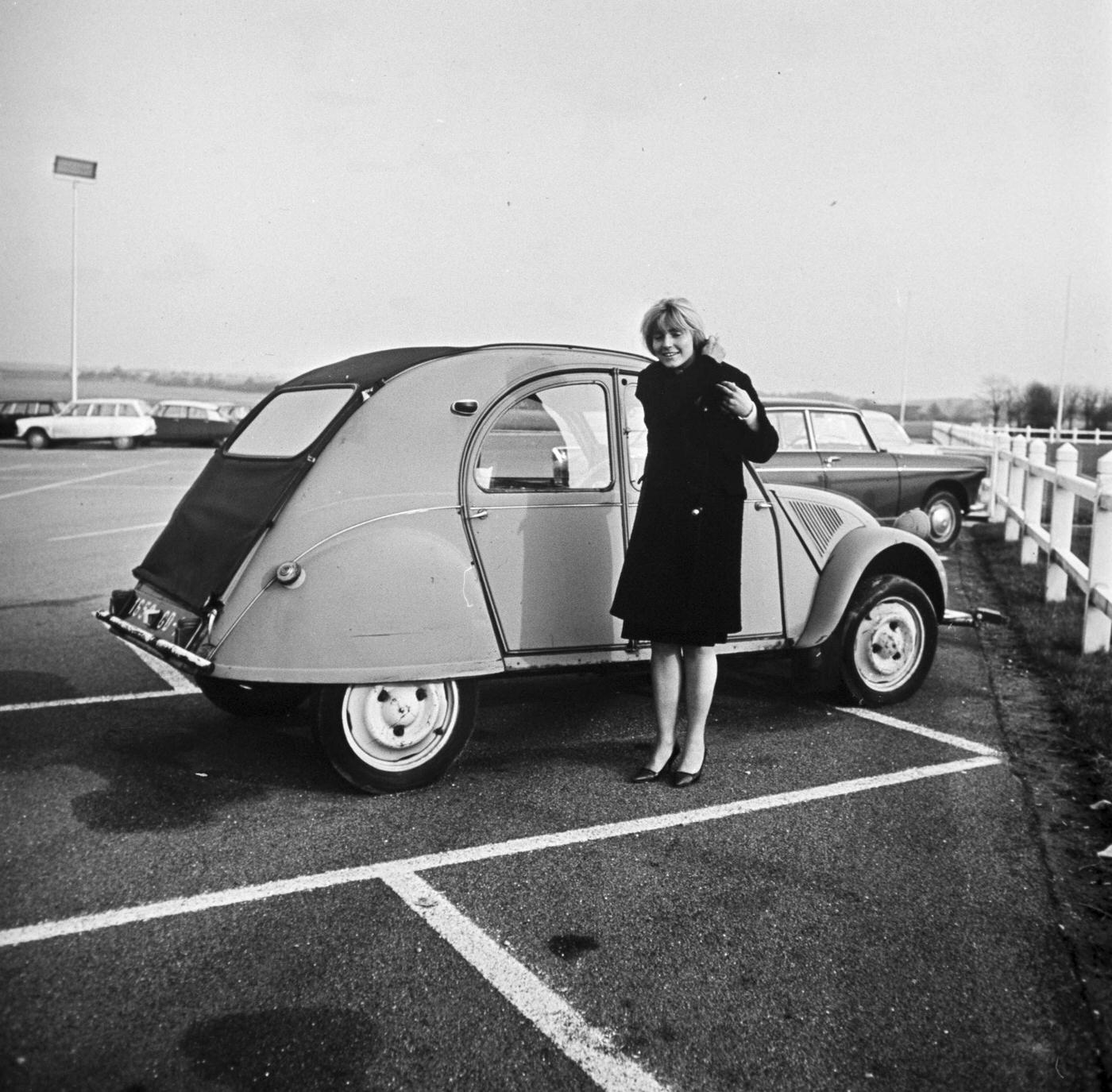 Jacqueline Dubut, the first female airline pilot hired by Air Inter, standing beside her Citroën 2CV, 1966.