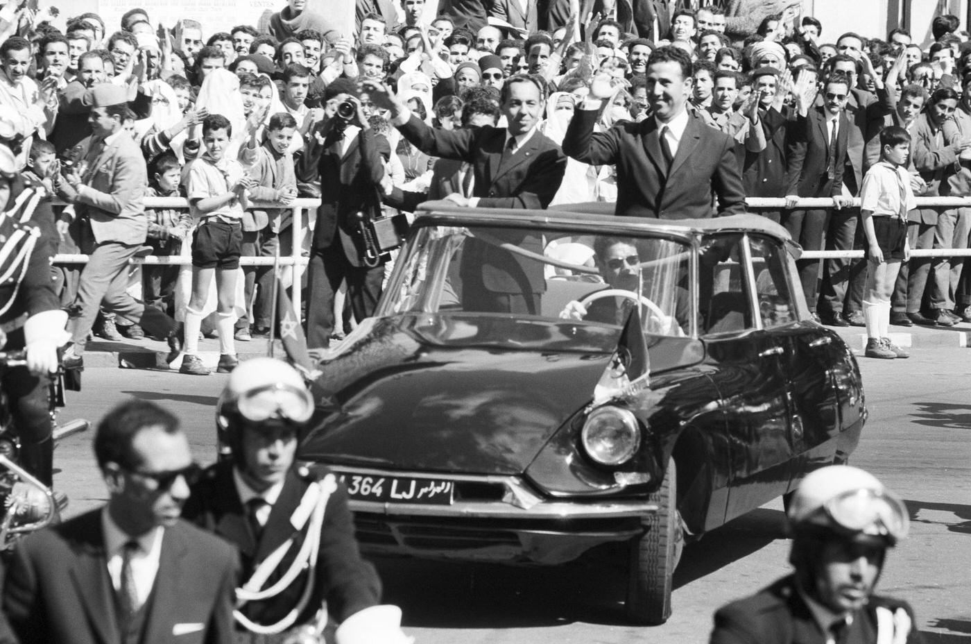 King Hassan II of Morocco and Ahmed Ben Bella, the first president of the Democratic and Popular Republic of Algeria, in a black convertible Citroën DS, 1963.