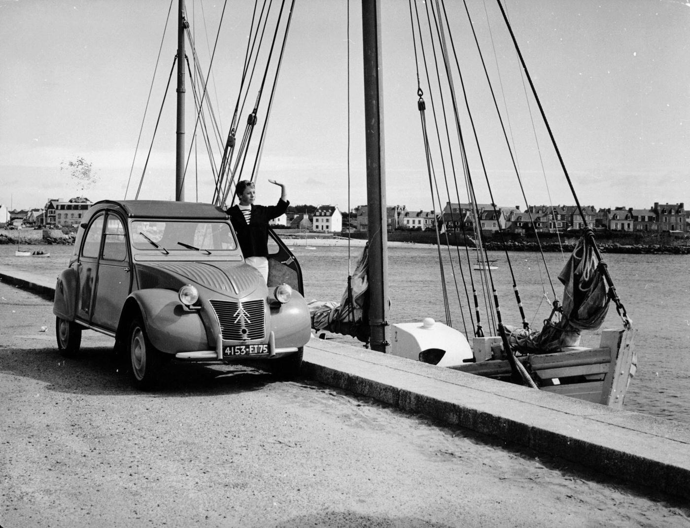 A Citroën 2CV parked on the quay at a harbor in 1957.