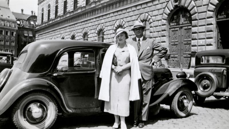 Couple with Citroën in historic town centre, 1935