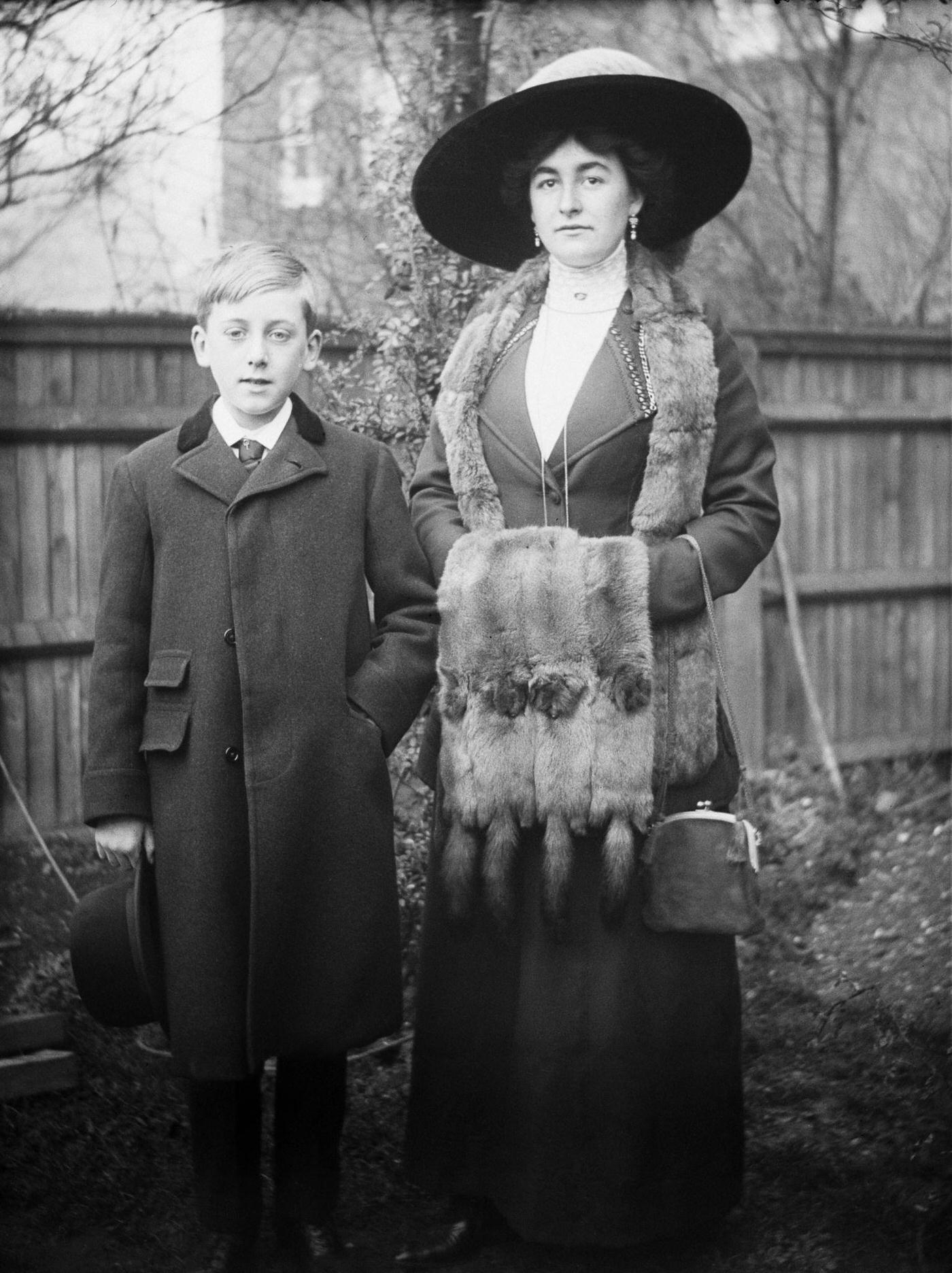 Joan Mainwaring and a young boy enjoy a playful moment in a backyard, 2nd November 1912