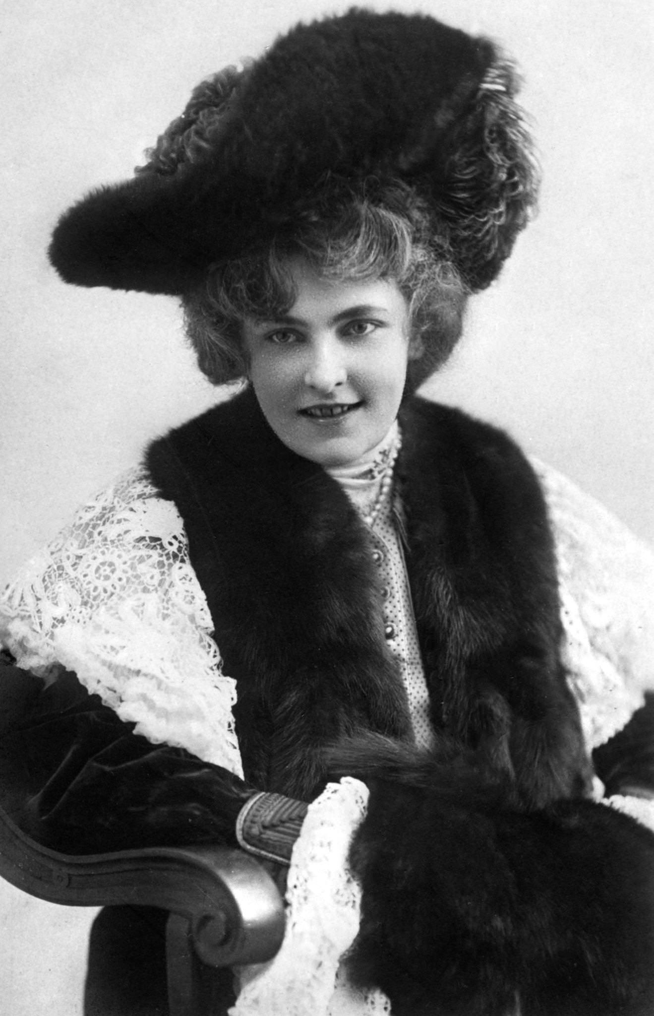 Marie Studholme poses elegantly in a stunning hat