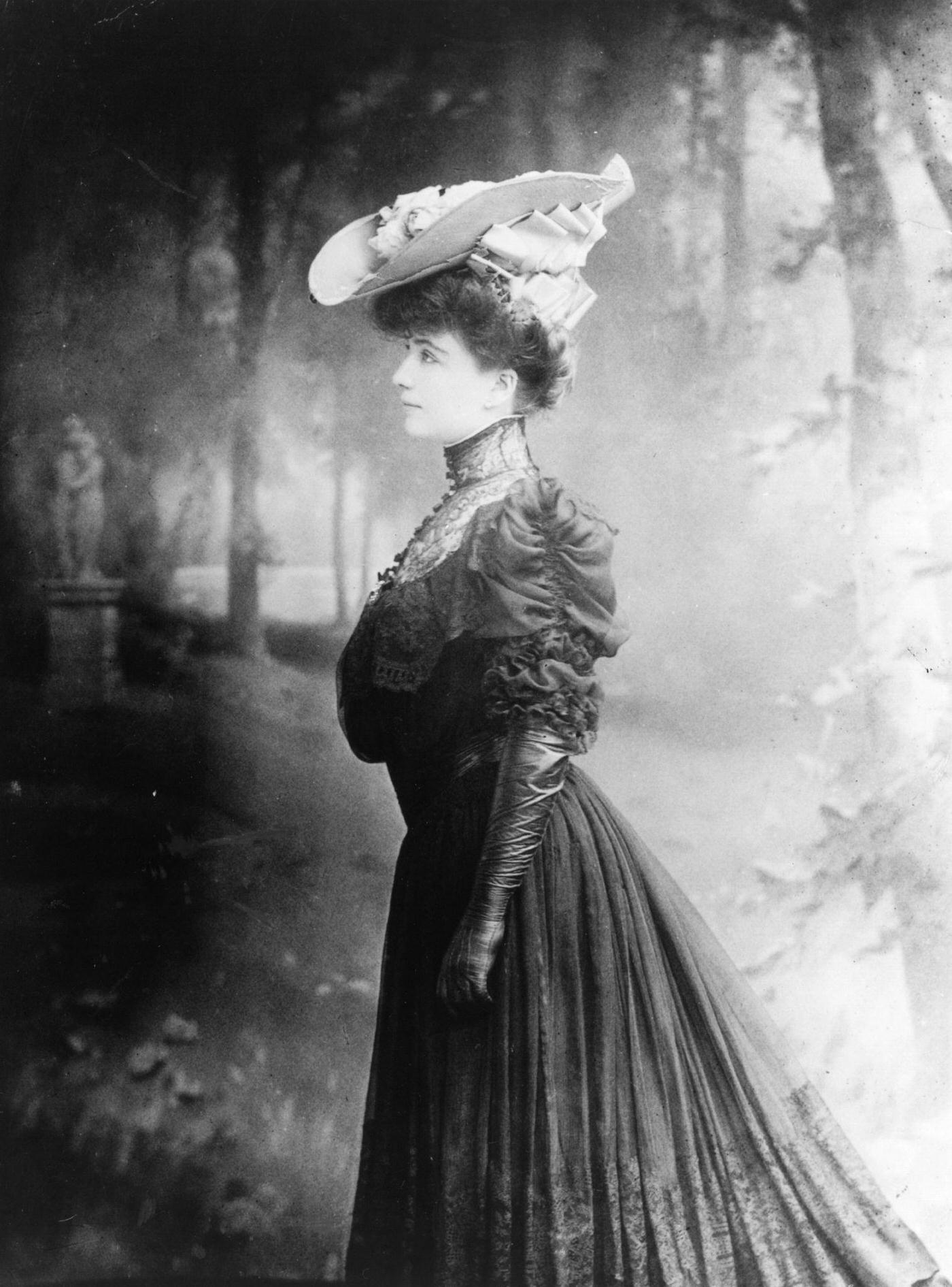 An Edwardian woman looks stunning in a fashionable outfit against the backdrop of woodlands in 1905