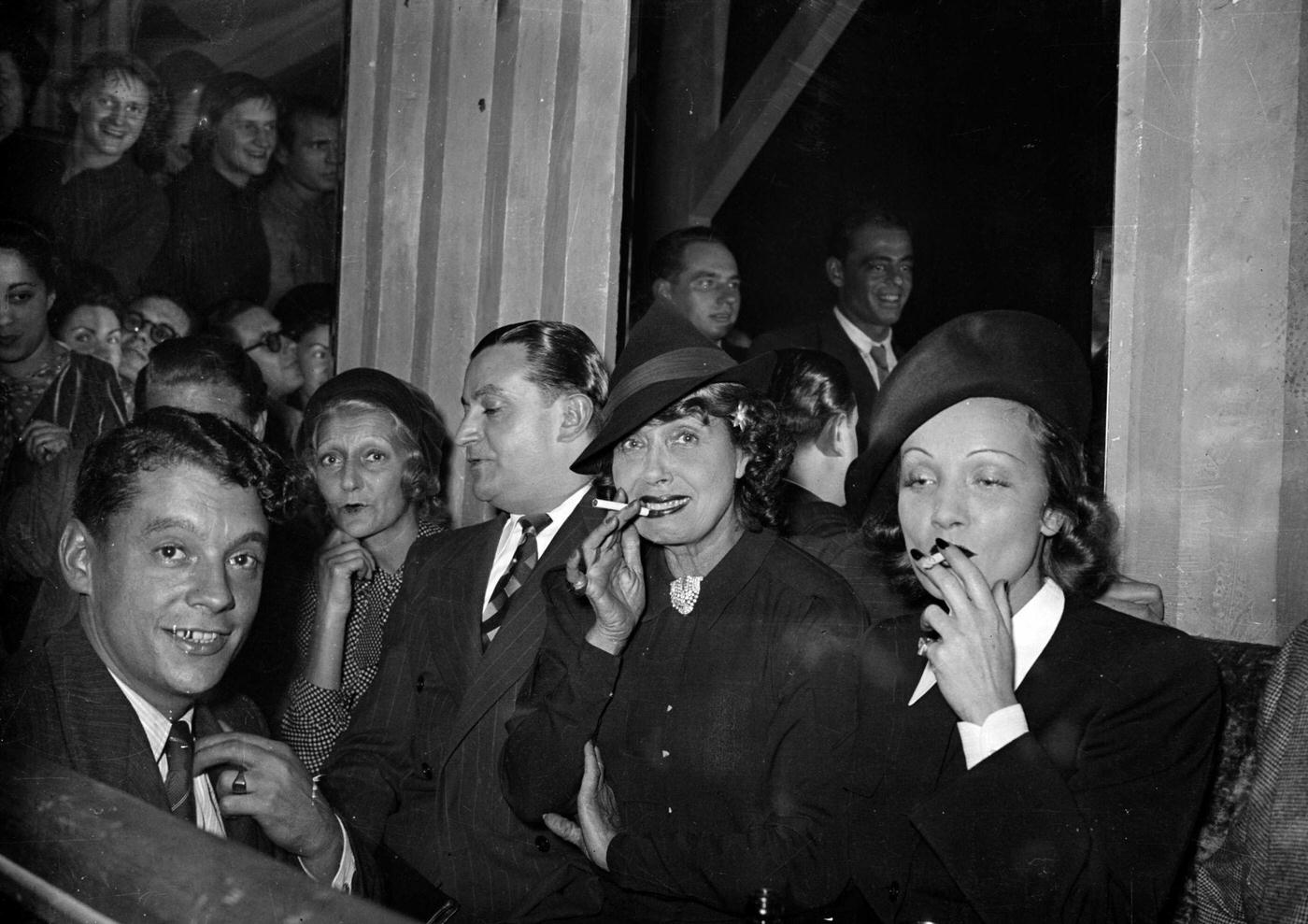 In the 1930s, Mistinguett and Marlene Dietrich are seen smoking together.