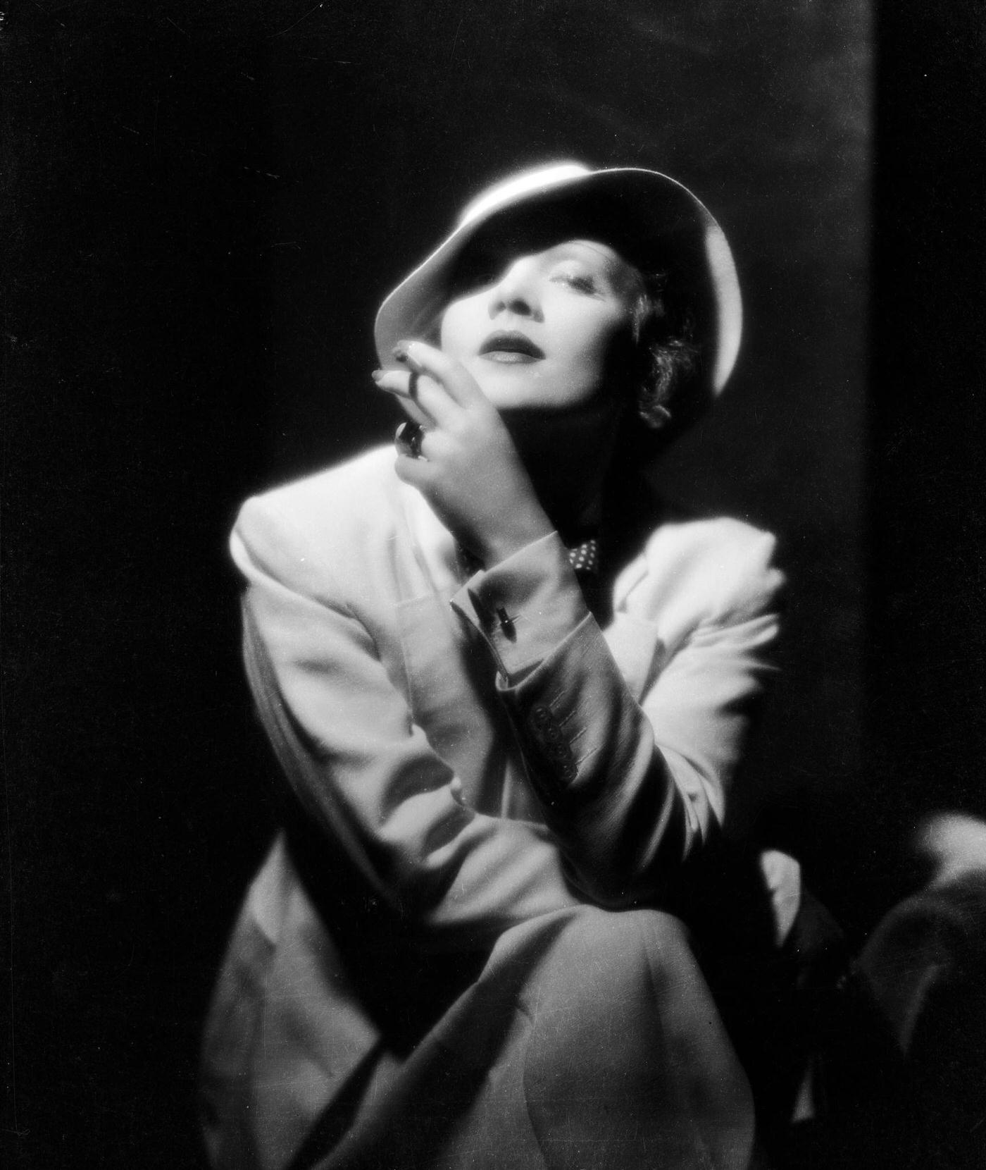 Marlene Dietrich wears a soft pull-on hat while smoking a cigarette.