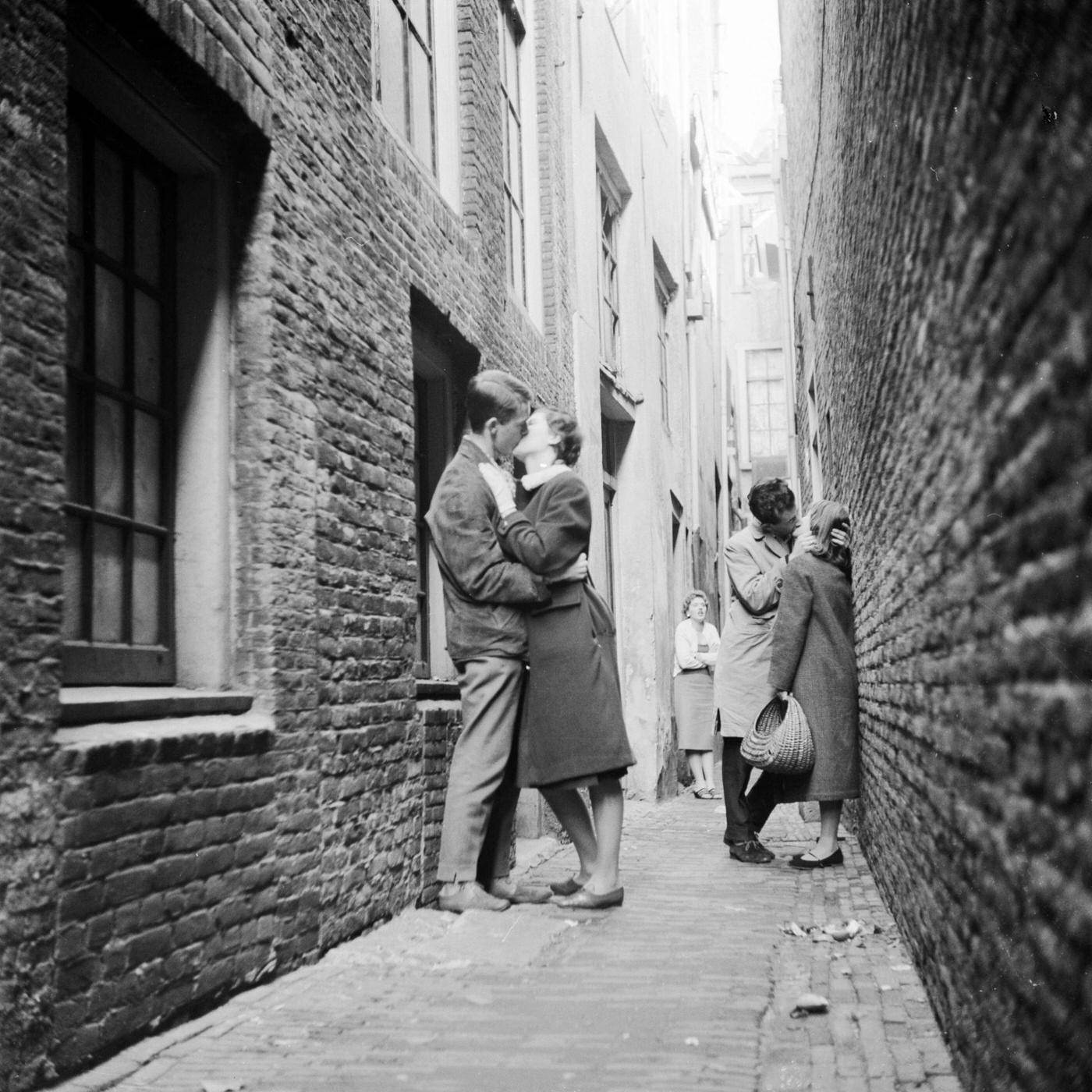Couples kissing in a narrow alley in the Netherlands, circa 1956.