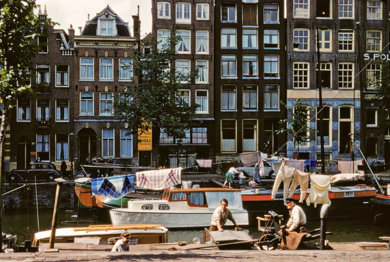 Carpet mender on Geldersekade Canal, Amsterdam, Netherlands.