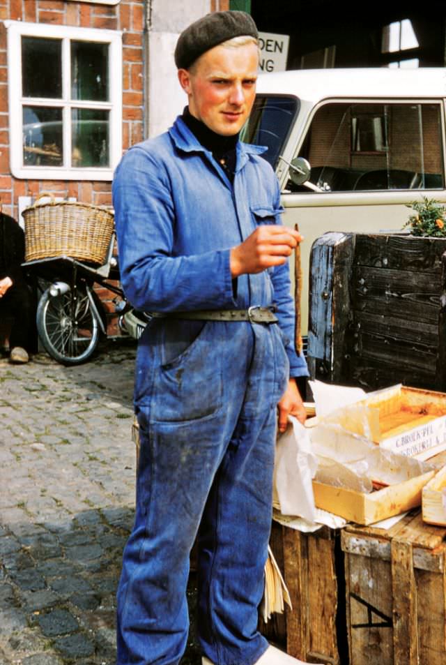 A fishery worker on a break holding a smoked eel, Veere Netherlands.