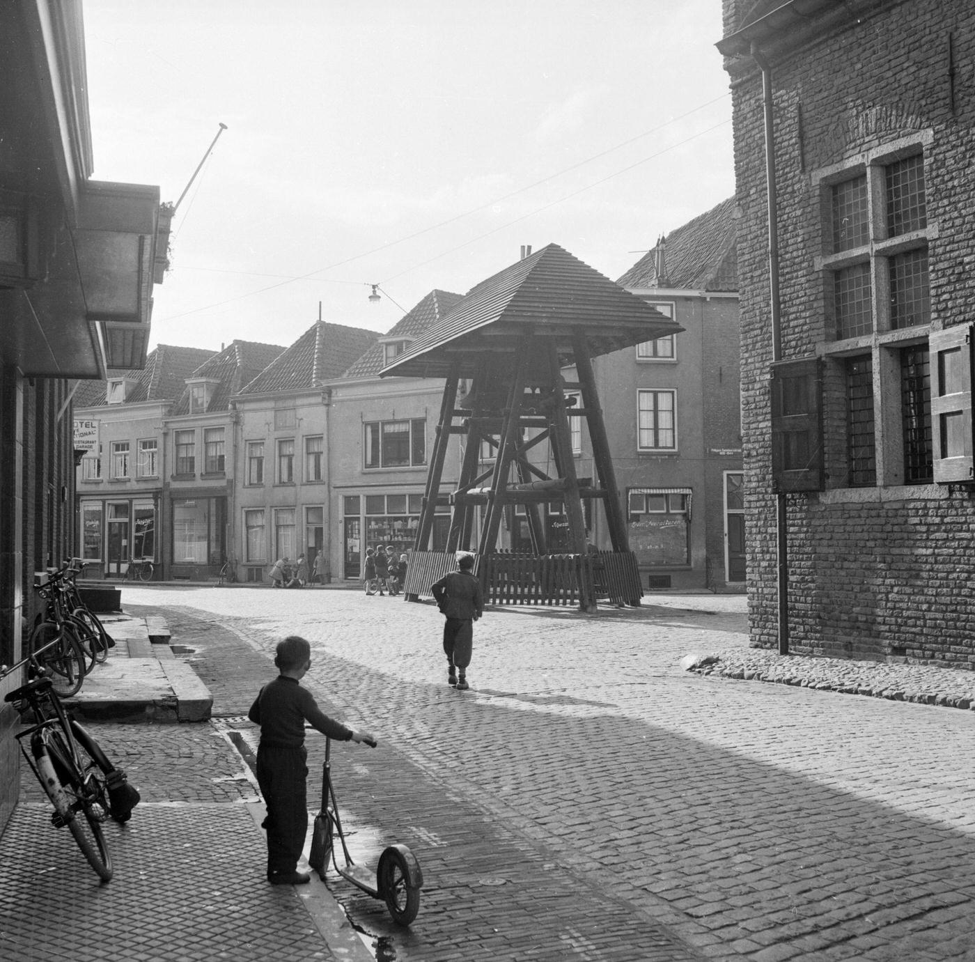 Child of the Haanapel family holds his scooter and watches the street in Doesburg, Netherlands, 16th May 1953.