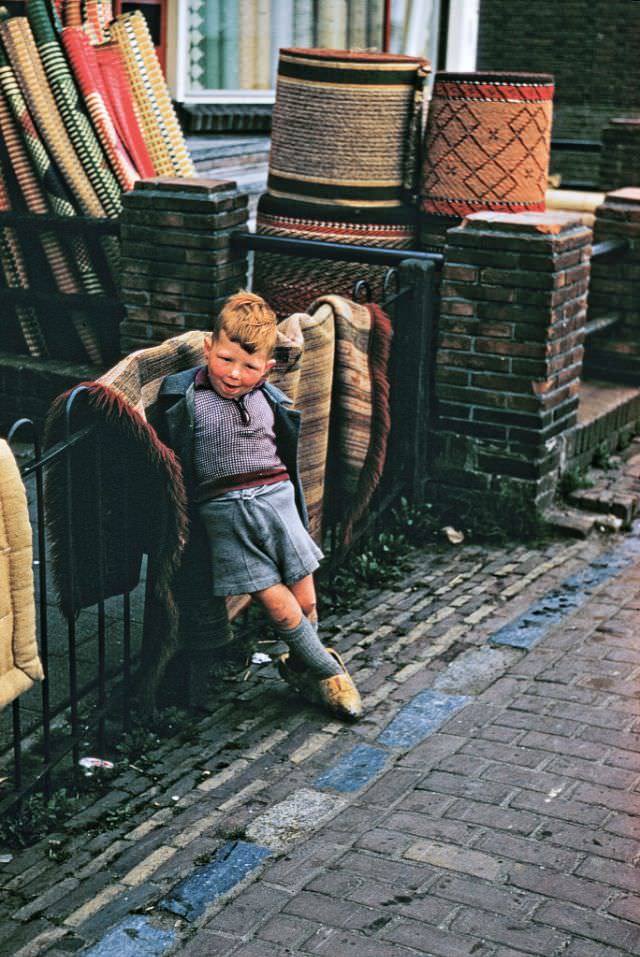A young boy outside carpet shop, Volendam.