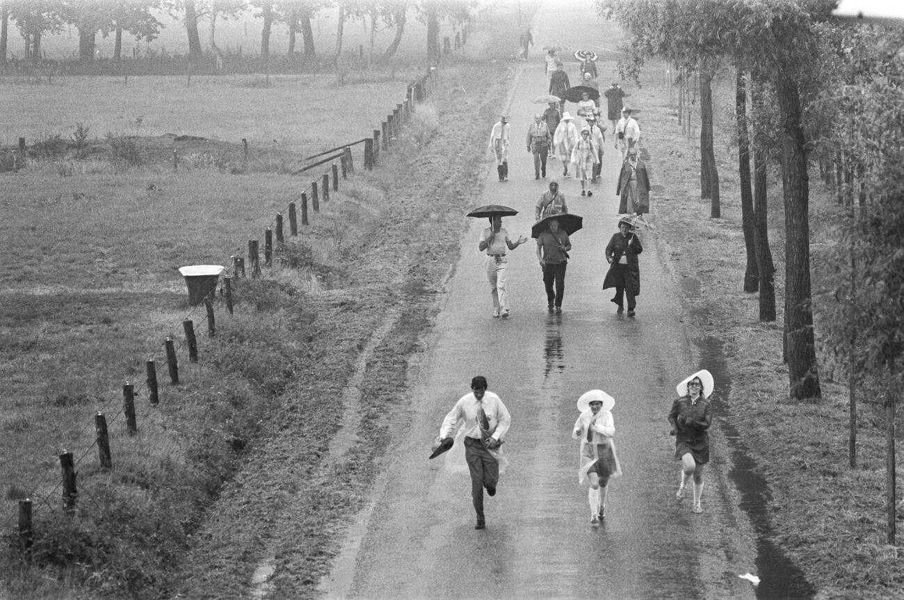 Participants starting the Apeldoorn Four Days Marches in the rain, with an overview on July 13, 1976.