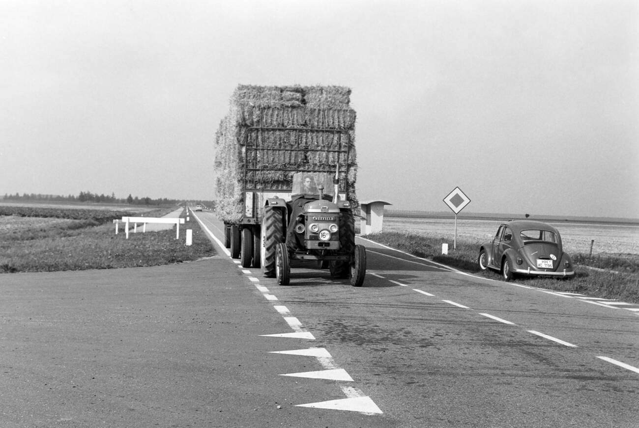 Tractor transporting hay on the street to Dronten at Flevoland province, The Netherlands in 1971