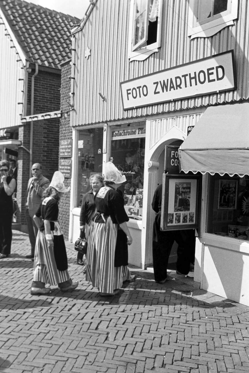 Family in traditional Dutch clothing walking through the streets of Monnickendam, The Netherlands in 1971