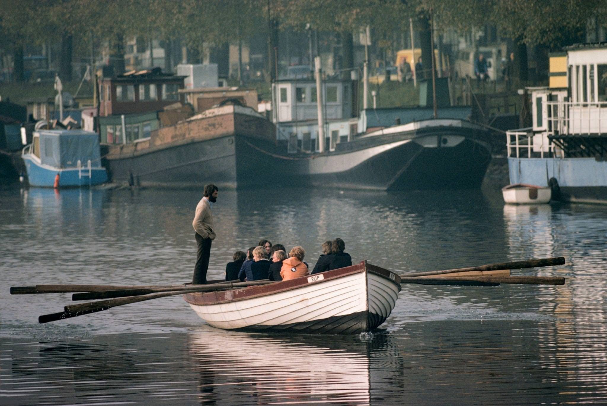 Cadets rowing on a canal with Dutch barges beyond in Amsterdam , May 1976